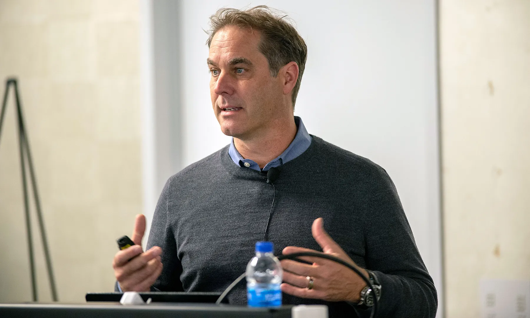 Andrew Dillion stands at a podium while giving a talk.