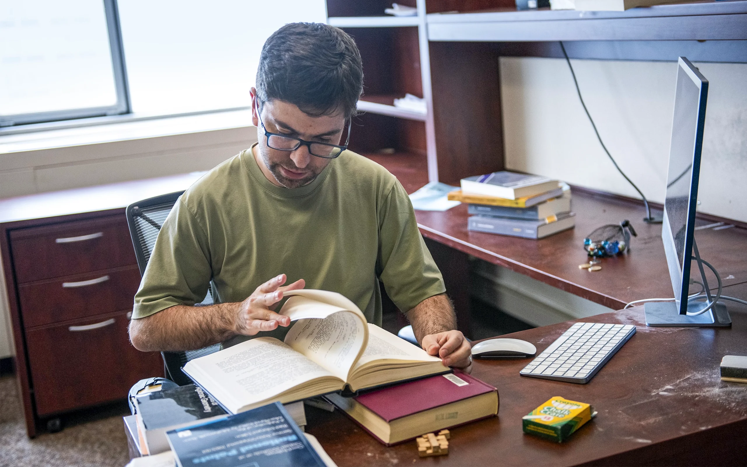 Litt reading a book at his desk.